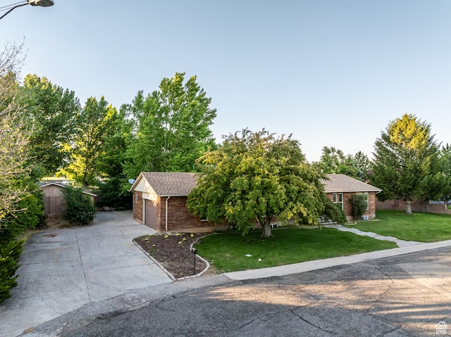 90 W 640 N, Richfield, UT 84701 - view of property hidden behind natural elements with brick siding, concrete driveway, a front lawn, a shingled roof, and a garage