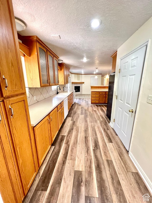 90 W 640 N, Richfield, UT 84701 - kitchen featuring a textured ceiling, freestanding refrigerator, a fireplace, wood finished floors, and glass insert cabinets
