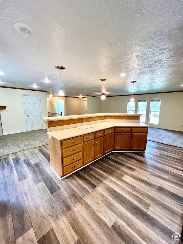 90 W 640 N, Richfield, UT 84701 - kitchen featuring open floor plan, a textured ceiling, dark wood-type flooring, light countertops, and brown cabinetry