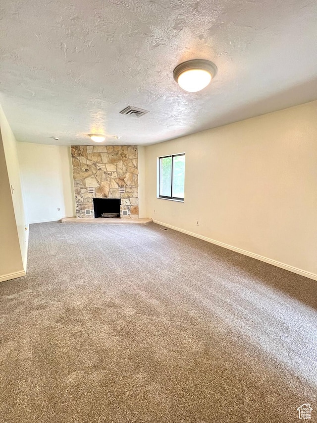 90 W 640 N, Richfield, UT 84701 - unfurnished living room featuring a textured ceiling, a stone fireplace, and carpet floors