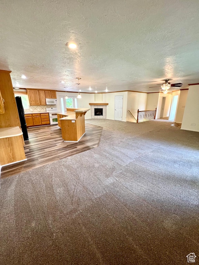 90 W 640 N, Richfield, UT 84701 - unfurnished living room featuring ceiling fan, carpet, a textured ceiling, a fireplace, and wood finished floors