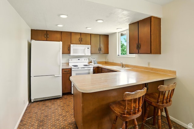 167 E 950 S, Layton, UT 84041 - kitchen with white appliances, light countertops, a peninsula, brown cabinetry, and a breakfast bar