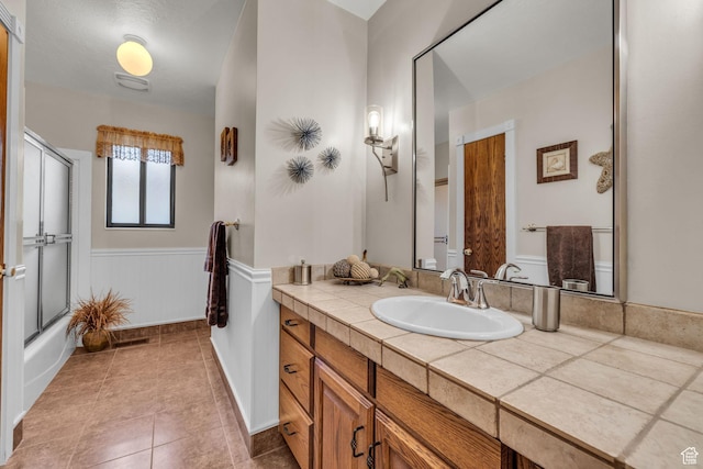 315 E Oak Ln, Kaysville, UT 84037 - bathroom featuring vanity, wainscoting, tile patterned floors, and shower / bath combination with glass door