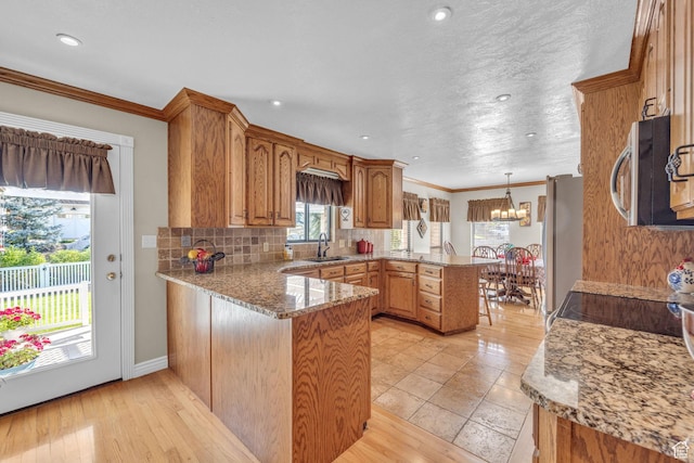 315 E Oak Ln, Kaysville, UT 84037 - kitchen with a peninsula, stainless steel appliances, a chandelier, tasteful backsplash, and ornamental molding