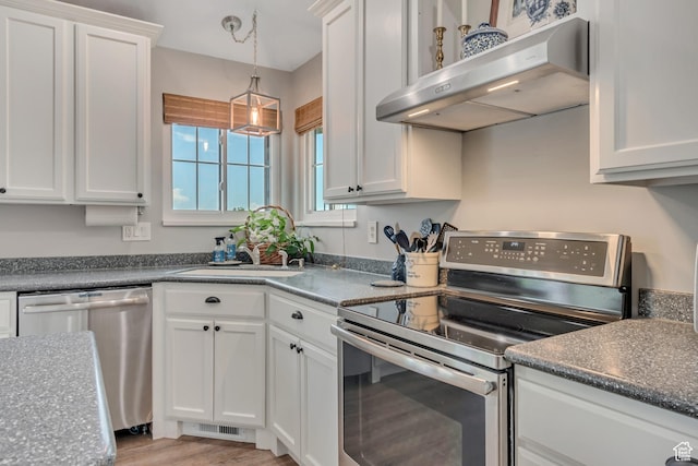 5718 W Silver Rose Cir S, Herriman, UT 84096 - kitchen with appliances with stainless steel finishes, under cabinet range hood, white cabinetry, hanging light fixtures, and light wood-style floors