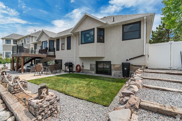 5718 W Silver Rose Cir S, Herriman, UT 84096 - back of property with a wooden deck, stucco siding, a patio area, and stairs
