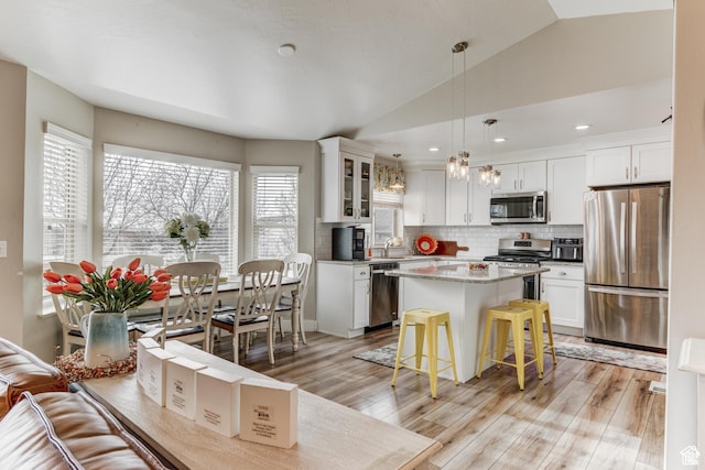 2631 Black Walnut Dr, North Logan, UT 84341 - kitchen featuring stainless steel appliances, white cabinetry, backsplash, light wood-style floors, and lofted ceiling
