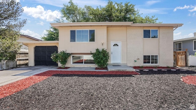 4445 S Honeywood Ln, West Valley City, UT 84120 - bi-level home with brick siding, an attached garage, and driveway