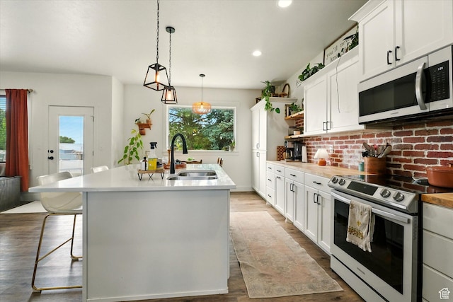 155 N 200 E, Richmond, UT 84333 - kitchen with stainless steel electric range oven, plenty of natural light, an island with sink, open shelves, and recessed lighting