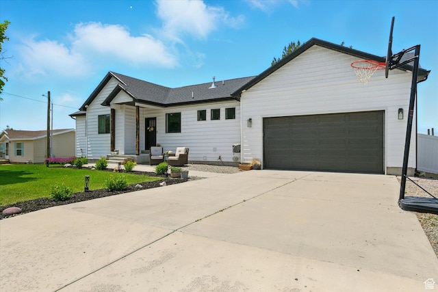 155 N 200 E, Richmond, UT 84333 - view of front of house featuring a garage, a front yard, concrete driveway, and an outdoor hangout area