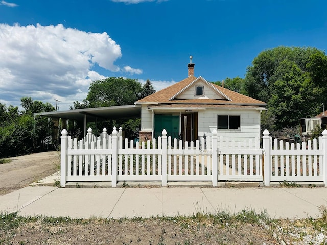 348 S Carbon Ave, Price, UT 84501 - bungalow-style house with a fenced front yard, a shingled roof, a chimney, and an attached carport