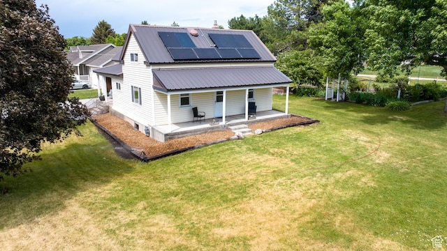 297 S 200 W, Richmond, UT 84333 - back of house featuring a porch, roof mounted solar panels, a lawn, and a metal roof