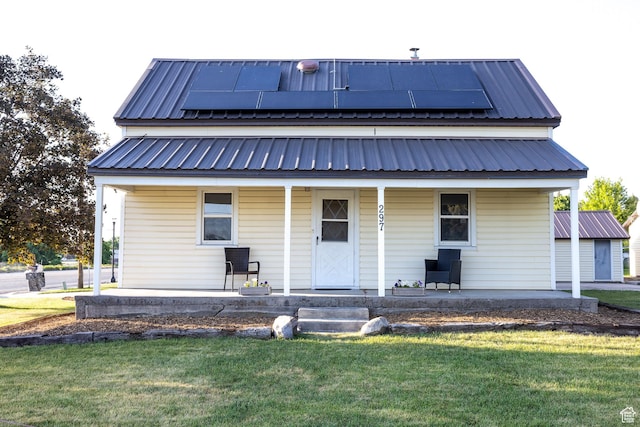 297 S 200 W, Richmond, UT 84333 - view of front facade featuring covered porch, a front yard, a metal roof, and solar panels