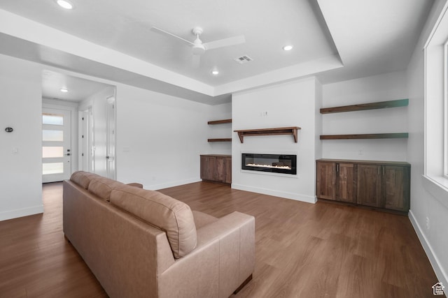 2154 S Bluff Dr, Cedar City, UT 84720 - living area featuring a glass covered fireplace, a ceiling fan, wood finished floors, recessed lighting, and a tray ceiling