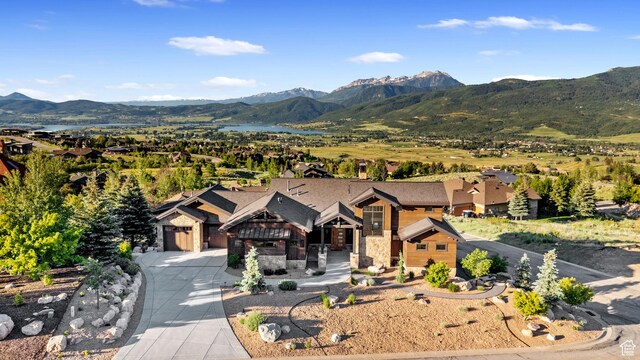 3911 N Zermatt St, Eden, UT 84310 - view of front of property featuring driveway, a mountain view, stone siding, and a garage