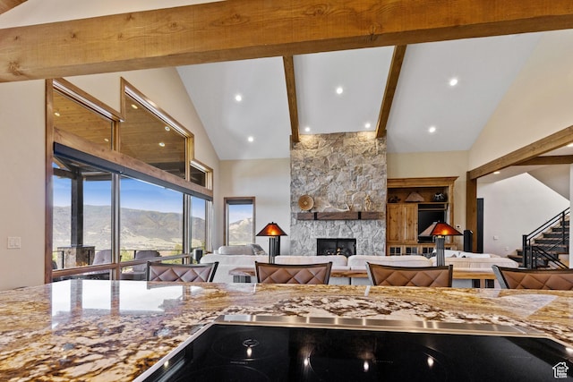3911 N Zermatt St, Eden, UT 84310 - kitchen featuring beam ceiling, a fireplace, open floor plan, light stone countertops, and high vaulted ceiling