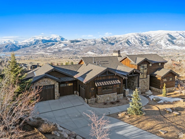 3911 N Zermatt St, Eden, UT 84310 - view of front of house featuring stone siding, a mountain view, concrete driveway, and an attached garage