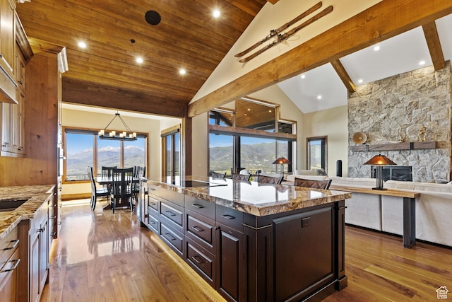 3911 N Zermatt St, Eden, UT 84310 - kitchen with dark wood-type flooring, a mountain view, wood ceiling, light stone countertops, and a fireplace
