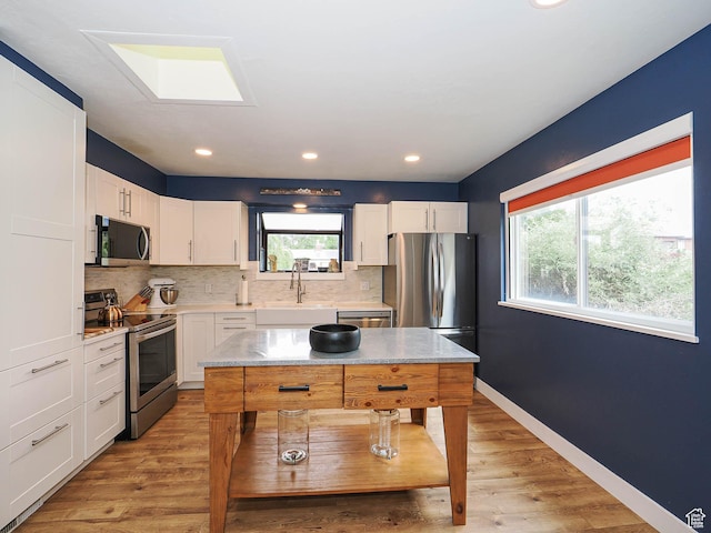 4601 S Creekview Cir, Murray, UT 84107 - kitchen featuring stainless steel appliances, tasteful backsplash, light wood-style flooring, white cabinets, and recessed lighting