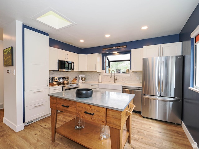 4601 S Creekview Cir, Murray, UT 84107 - kitchen featuring stainless steel appliances, light wood-type flooring, white cabinetry, tasteful backsplash, and recessed lighting