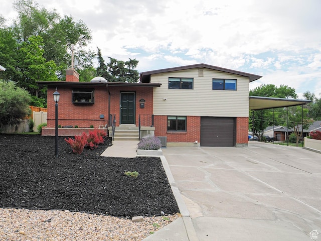4601 S Creekview Cir, Murray, UT 84107 - split level home with brick siding, an attached garage, concrete driveway, and a chimney