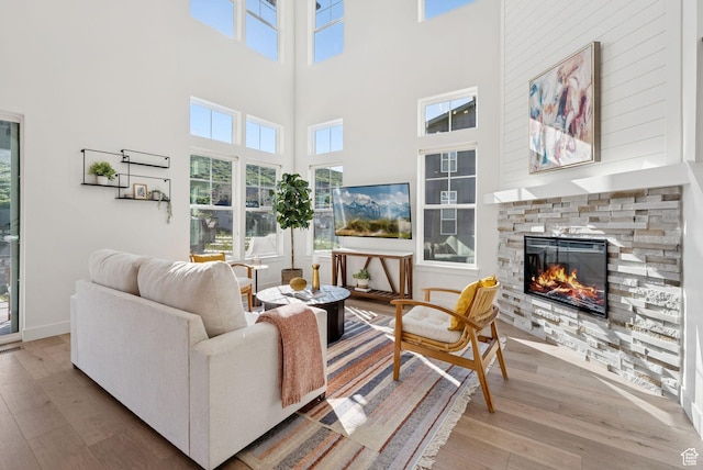12756 N Belaview Way, Hideout, UT 84036 - living area featuring wood finished floors, a stone fireplace, and a high ceiling