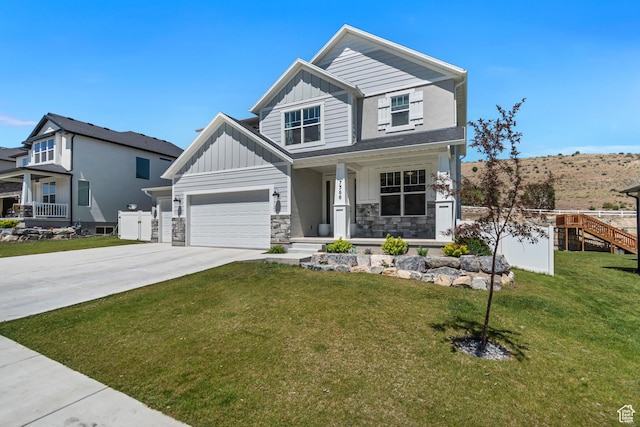 7366 N Golden Summit Dr, Eagle Mountain, UT 84005 - craftsman-style house with board and batten siding, a porch, concrete driveway, a front yard, and stone siding