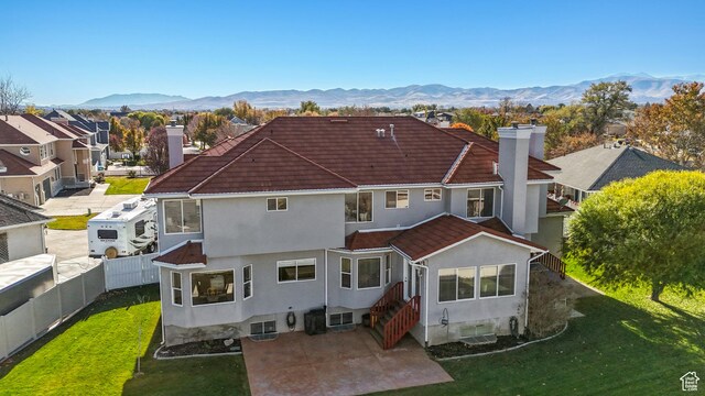 11694 S Stone Crest Cir W, Riverton, UT 84065 - back of property with a chimney, stucco siding, a mountain view, a tile roof, and a residential view