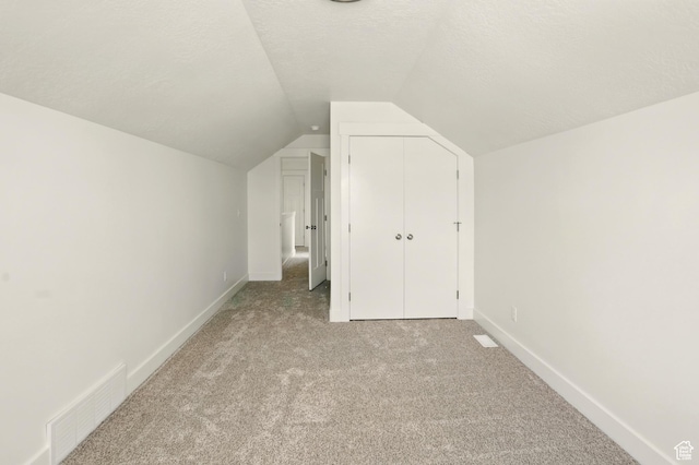 1154 E 1150 S, Garland, UT 84312 - additional living space with light colored carpet, lofted ceiling, and a textured ceiling