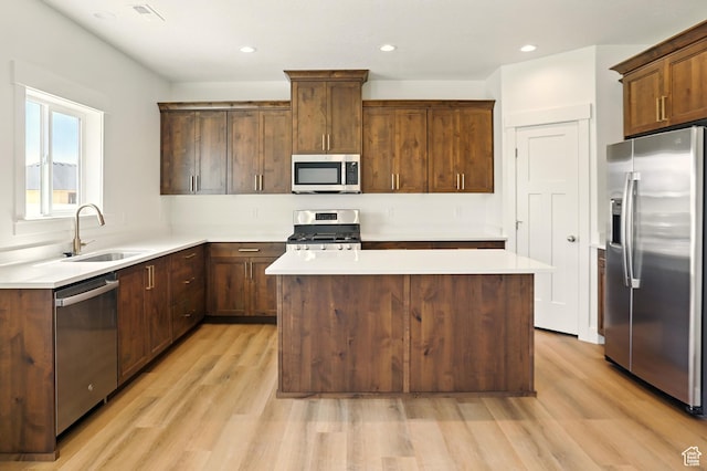 1154 E 1150 S, Garland, UT 84312 - kitchen with appliances with stainless steel finishes, light wood finished floors, a kitchen island, light countertops, and recessed lighting