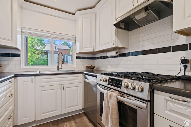 2402 S Elizabeth St Unit 5, Salt Lake City, UT 84106 - kitchen featuring appliances with stainless steel finishes, under cabinet range hood, dark countertops, white cabinets, and crown molding