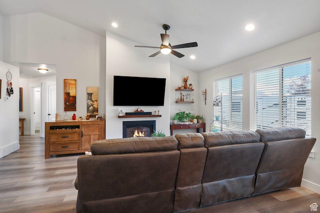 4764 N Gunsight Peak Dr, Eagle Mountain, UT 84005 - living room with vaulted ceiling, a ceiling fan, a glass covered fireplace, wood finished floors, and recessed lighting