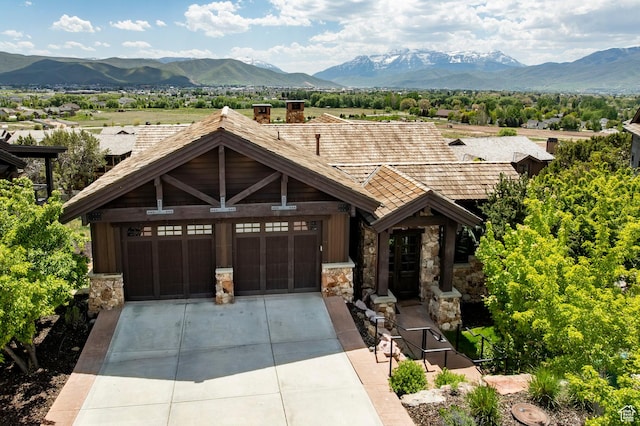 285 N Kings Peak Ct, Heber City, UT 84032 - view of front of property with stone siding, a mountain view, driveway, a chimney, and a garage