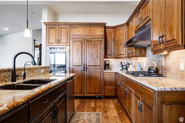 285 N Kings Peak Ct, Heber City, UT 84032 - kitchen featuring under cabinet range hood, stainless steel appliances, dark wood-style floors, light stone counters, and decorative backsplash