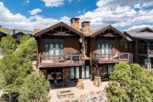 285 N Kings Peak Ct, Heber City, UT 84032 - rear view of house featuring a patio area, stone siding, a chimney, an outdoor fire pit, and french doors
