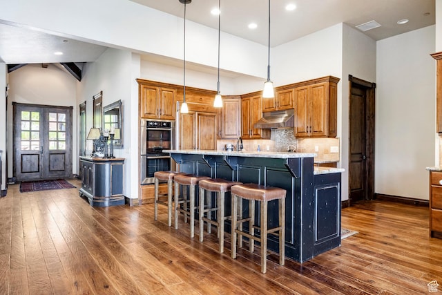 285 N Kings Peak Ct, Heber City, UT 84032 - kitchen featuring double oven, under cabinet range hood, dark wood-style flooring, brown cabinetry, and recessed lighting