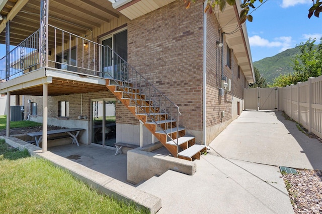 3195 E Willowcrest S, Cottonwood Heights, UT 84121 - view of side of property featuring brick siding, a gate, a mountain view, and a patio