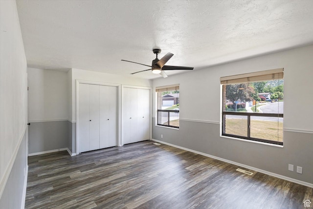 3195 E Willowcrest S, Cottonwood Heights, UT 84121 - unfurnished bedroom with two closets, dark wood-style floors, a textured ceiling, and ceiling fan