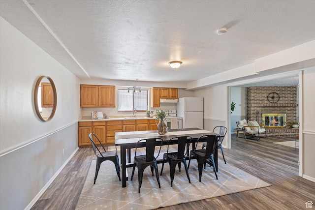3195 E Willowcrest S, Cottonwood Heights, UT 84121 - dining room with a fireplace, wood finished floors, and a textured ceiling