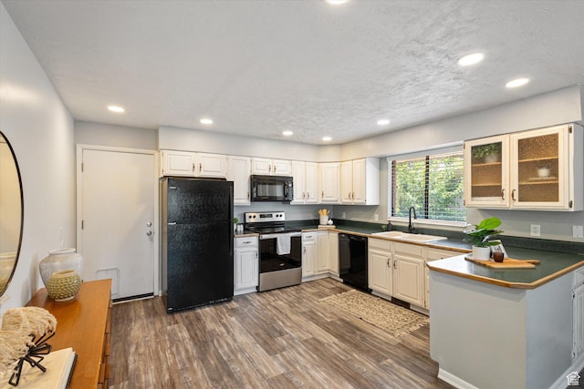 3195 E Willowcrest S, Cottonwood Heights, UT 84121 - kitchen featuring black appliances, wood finished floors, dark countertops, a peninsula, and glass insert cabinets