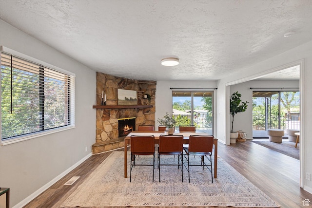 3195 E Willowcrest S, Cottonwood Heights, UT 84121 - dining area featuring a textured ceiling, wood finished floors, and a stone fireplace