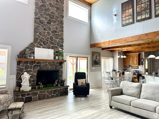 840 S Williams Cv W, Salem, UT 84653 - living area featuring beam ceiling, light wood-style floors, a high ceiling, wainscoting, and a stone fireplace