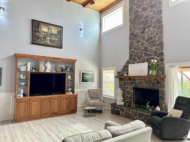 840 S Williams Cv W, Salem, UT 84653 - living room featuring light wood-style flooring, a wooden ceiling with exposed beams, high vaulted ceiling, a wainscoted wall, and a stone fireplace