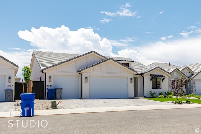 2818 E Rill Dr, Washington, UT 84780 - view of front of house with an attached garage, a tile roof, board and batten siding, and decorative driveway