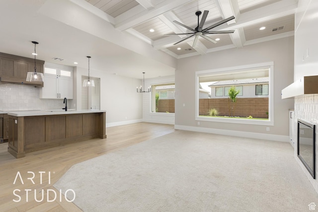 2818 E Rill Dr, Washington, UT 84780 - kitchen with light countertops, a tiled fireplace, backsplash, a ceiling fan, and beam ceiling