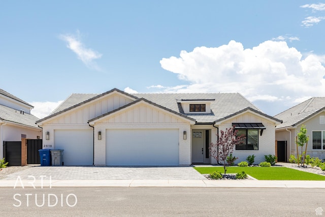 2818 E Rill Dr, Washington, UT 84780 - modern farmhouse style home featuring board and batten siding, brick siding, a garage, decorative driveway, and a front yard
