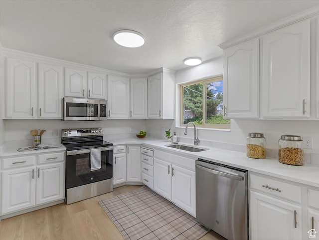 8359 S Fayeway Dr, Sandy, UT 84094 - kitchen with appliances with stainless steel finishes, white cabinetry, and light wood-style flooring