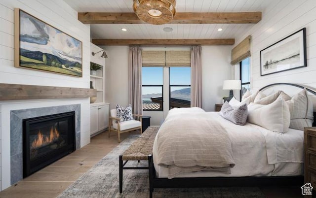 4578 N Solstice Dr Unit 332, Lehi, UT 84043 - bedroom featuring light wood finished floors, beam ceiling, a glass covered fireplace, and recessed lighting