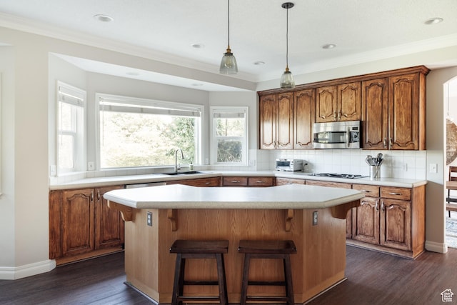 9788 S Dante Rd E, Sandy, UT 84092 - kitchen with stainless steel microwave, a kitchen island, tasteful backsplash, dark wood-style flooring, and light countertops