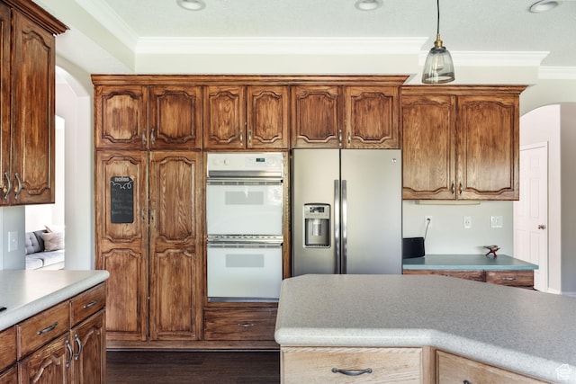 9788 S Dante Rd E, Sandy, UT 84092 - kitchen with stainless steel fridge, white double oven, ornamental molding, dark wood-type flooring, and arched walkways